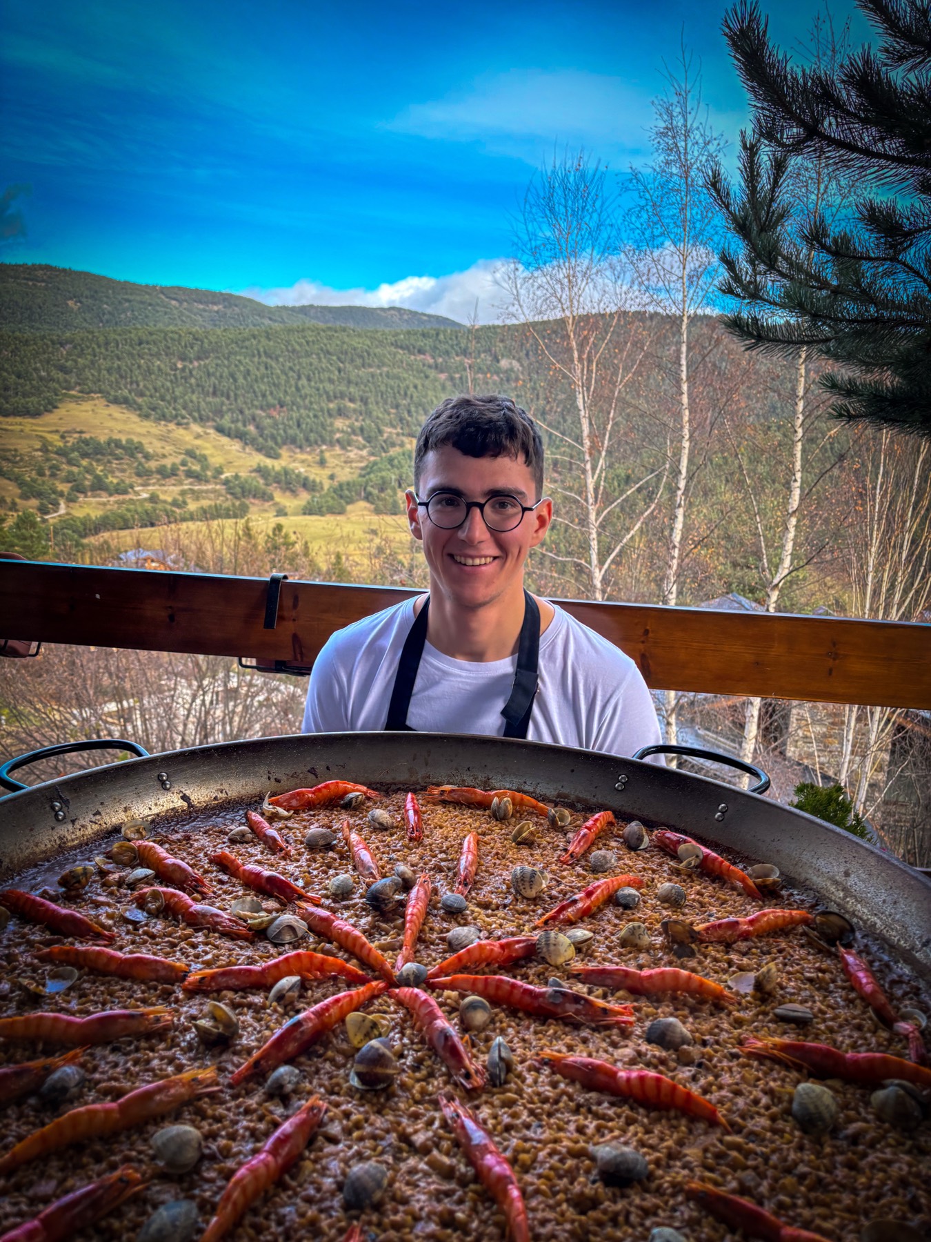 Jaume detrás de una paella de gambas y almejas en la montaña